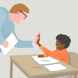 Teacher high-fiving young student in classroom