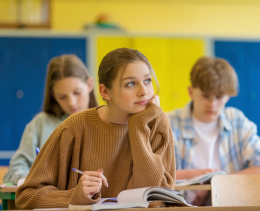 Female student in a classroom reflecting on her learning