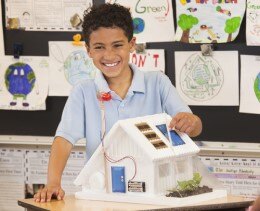 Young male student showcasing his work on sustainability to the class