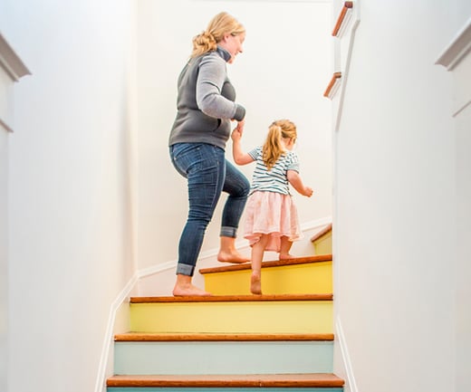 Parent leading child up stairs 