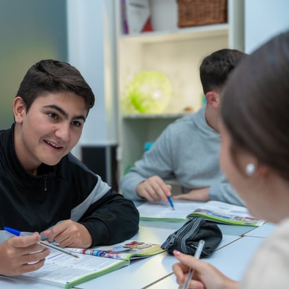 Two students writing and talking together