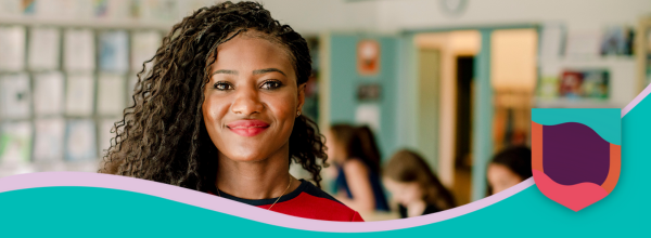 Female teacher in a classroom smiling at camera